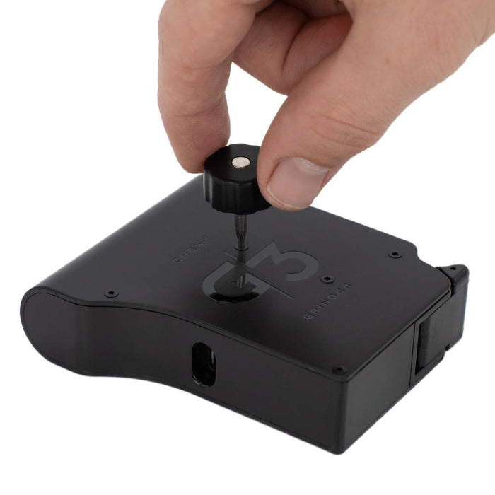 Chewy G3 Electronic Grinder Basic Edition Black laying down with hand opening using a tool.