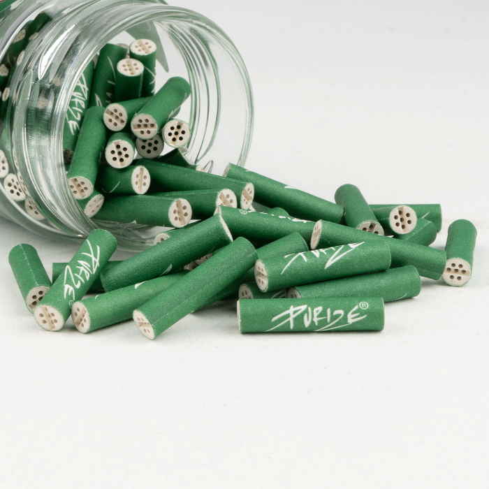 Purize XTRA Slim 100 Green opened glass jar with filter tips spilling out.