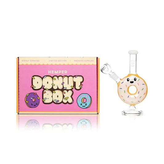 Hemper Donut Bong 6.5″ with matching illustrated box, featuring a colorful donut-shaped design with frosting and sprinkle details.
