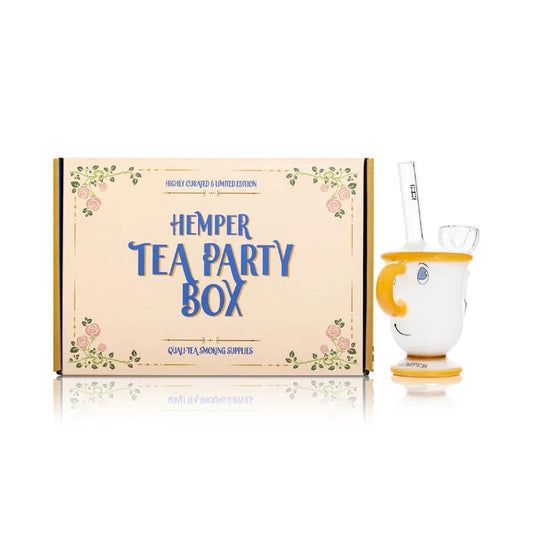 Hemper Tea Cup Bong 6″ with matching illustrated box, featuring a tea cup-shaped glass bong with vibrant colors and playful design for a fun smoking experience.