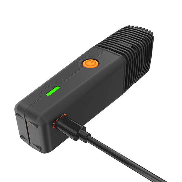 Storz & Bickel VEAZY Alluring Black vaporizer lying down with charging cable connected.